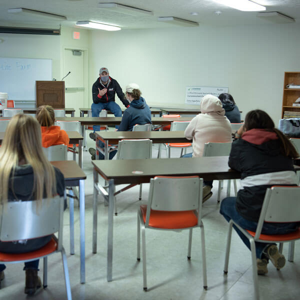 A professor lectures to his classroom of students.
